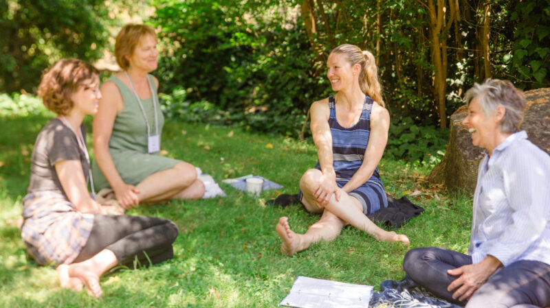 A group sits in a circle outside