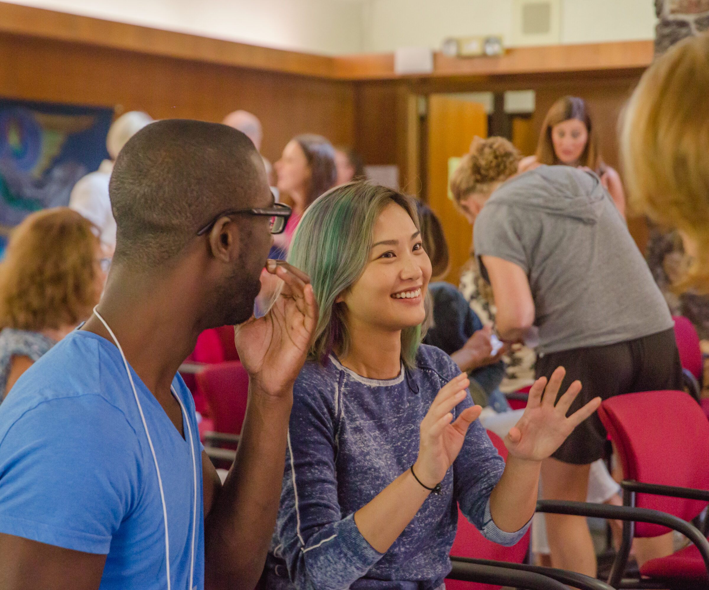 A woman speaks animatedly with her hands at an Enneagram Training